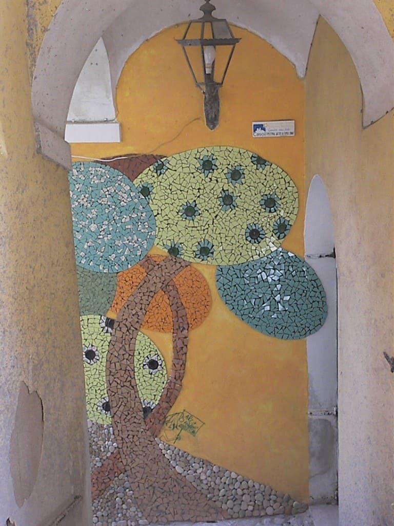Ein zeitgenössisches Mosaik unter einem Bogen des historischen Ortskerns
